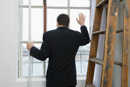 Rear view of a businessman looking through a window