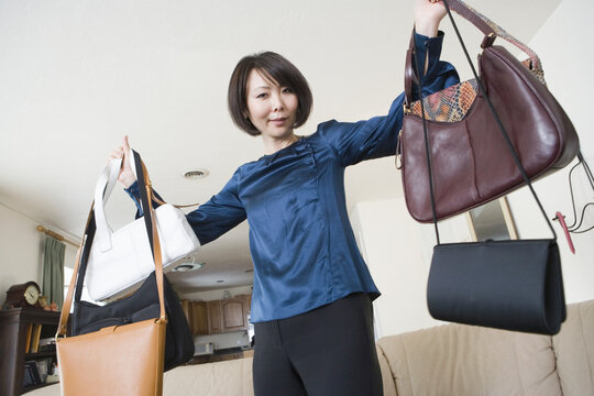 Portrait of a mid adult woman showing off purses