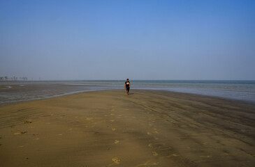 Naklejka premium south asian young boy walking on the beach