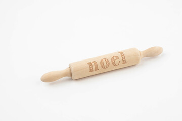 Wooden rolling pin that says Noel on white background 