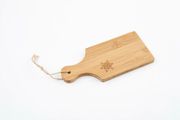 Wooden cutting board with snowflake on white background
