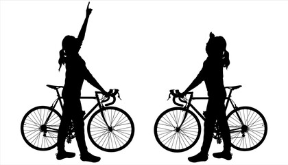 Two girls with bicycles. The girl holds the steering wheel of a bicycle with her hand, with the other hand she shows the direction up. The other girl is staring at the direction of the hand up.