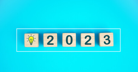 2023 New Year Goal Target, Action, Plan, Idea, Inspiration Concept. 2023 wooden cube with light bulb icon on light blue background. 2023 Concept.