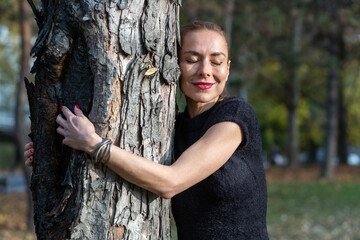 woman giving a hug to a tree in park