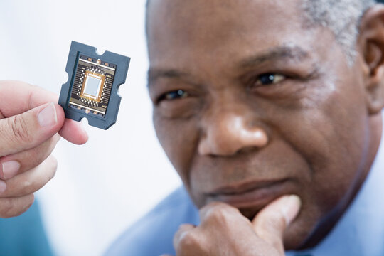 Close-up of a middle-aged man looking at a computer chip