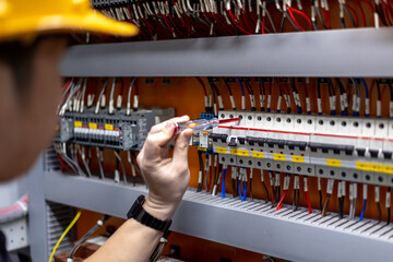 Engineer hand is using electric screwdriver to inspect electrical system in repair and maintenance concept.