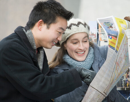 Young couple looking at a map and smiling