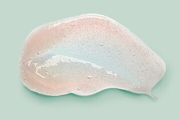 Cosmetic pink scrub peeling gel or foam swatch smudge on mint green background