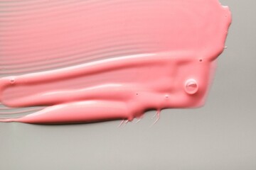 Purple pink lip gloss or peel-off mask with shimmer textured on gray background