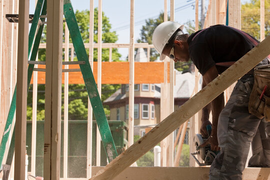 Carpenter using a circular saw at a construction site
