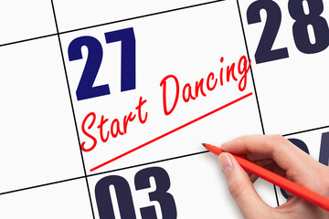 27th day of the month. Hand writing text START DANCING and drawing a line on calendar date.