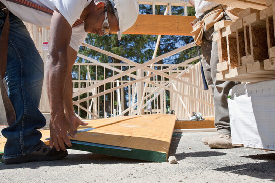 Carpenters working on a lamination beam at a construction site