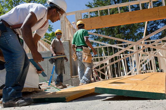Carpenters working on a lamination beam at a construction site