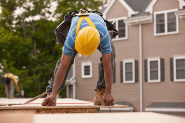 Carpenter measuring a particle board for trimming