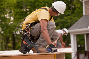 Carpenters laying a snap line on a particle board using chalk line