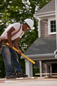 Carpenter using sledge hammer