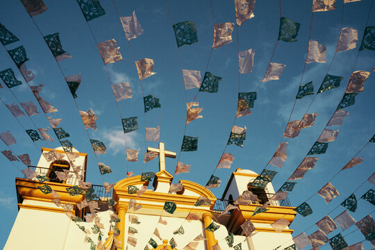 Flags hanging near aged church on sunny day