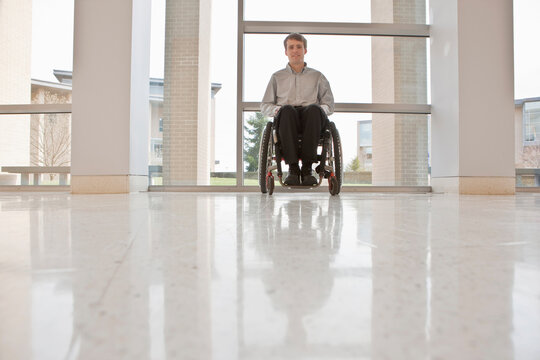 Businessman with spinal cord injury in a wheelchair in an office building