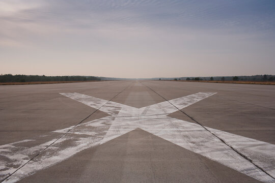 Old airport runway with cross in the floor