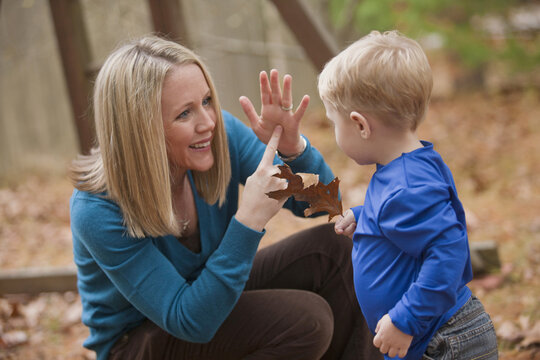 Woman signing the word 'Leaf' in American Sign Language while communicating with her son