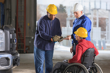 Automotive technician at power plant garage signing off on work log, supervisor in wheelchair