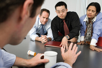 View of businesspeople conversing about drugs in an office.