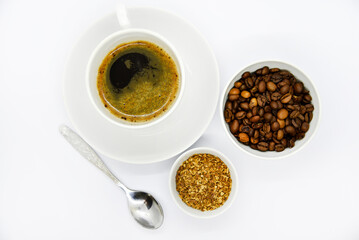 Porcelain coffee cup on a white background. Delicious coffee in a cup and coffee beans. Instant coffee and coffee beans close-up.