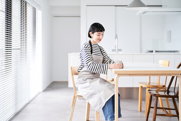 エプロン姿で休憩する若い女性