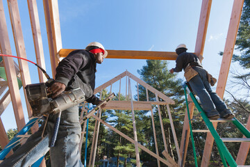 Carpenters bringing tools for installing beam