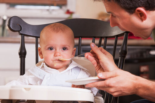 Father feeding food to his son with spoon