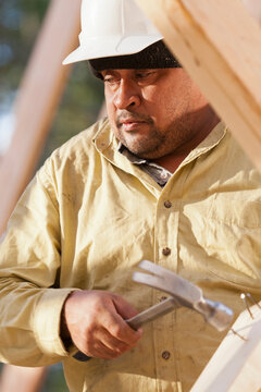 Carpenter removing nails from stud