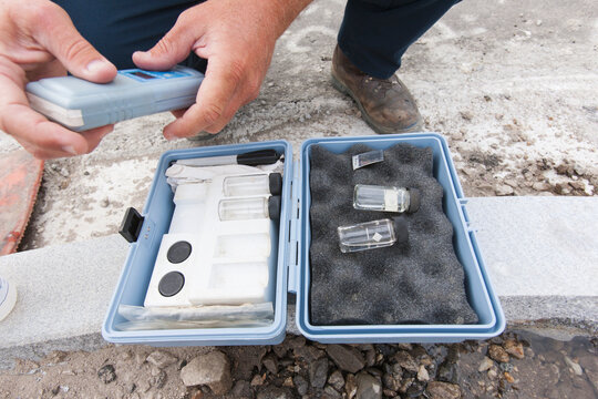 Water sample kit for public water testing and engineer holding chlorine instrument