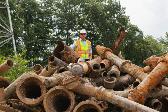Engineer with old water pipes removed from city piping underground
