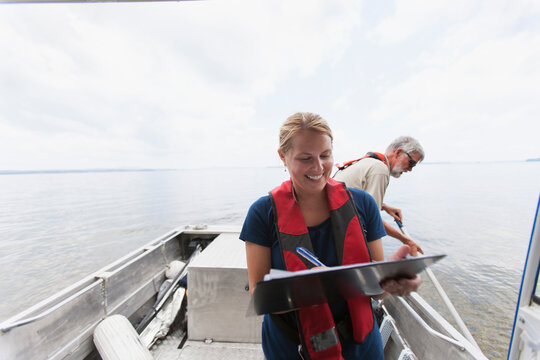 Engineer recording water sample data on board boat in public water supply