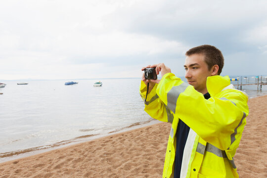Public works engineer photographing lake where water samples are taken