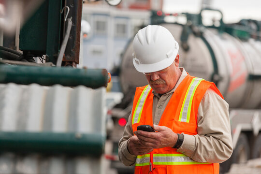 Environmental engineer on cell phone with tank truck at hazardous waste cleanup site