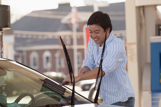 Chinese man washing his car windshield