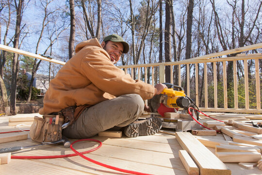 Hispanic carpenter using chop saw to cut deck railing cap