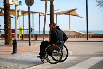Woman in wheelchair crossing the street in Fuengirola Spain