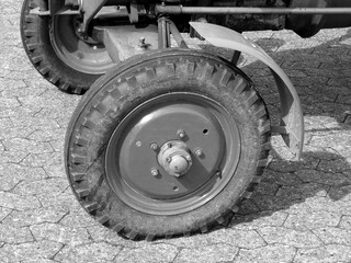 Vorderrad mit Schutzblech eines alten Traktor der Sechzigerjahre im Sonnenschein auf beim...