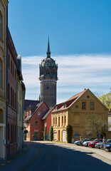 Fototapeta premium Gasse in der historischen Altstadt von Wittenberg. Im Hintergrund der Turm der Schlosskirche