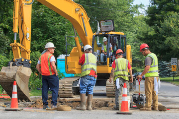 Construction workers digging hole to replace watermain