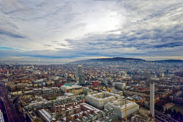 Obraz premium Aerial view of City of Zürich seen from industrial district with Höngg District in the background on a cloudy winter day. Photo taken December 20th, 2022, Zurich, Switzerland.