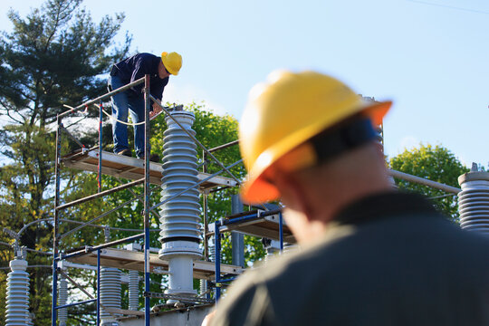 Power engineer performing maintenance on fluid filled high voltage insulator