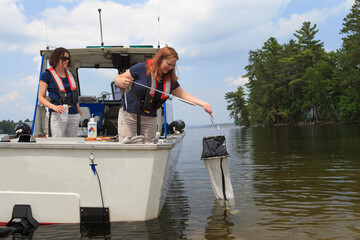 Water treatment engineers collecting samples using sieve