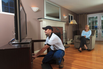 Cable installer working with TV in a home
