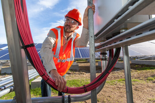 Solar photovoltaic installer working on power connections for a PV array