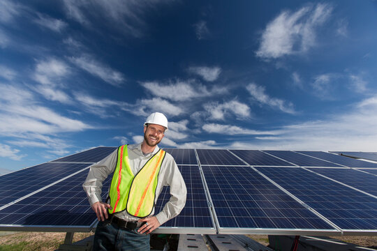 Solar photovoltaic installer standing in front of a PV array