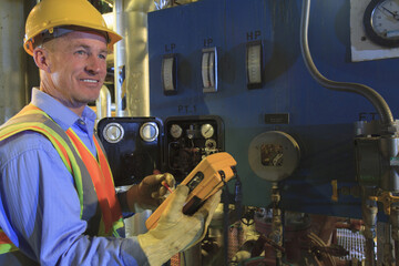 Engineer in electric power plant using a voltmeter to verify sensor readings