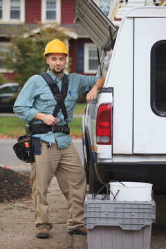 Tradesman retrieving supplies from an open hatch on the side of his work truck